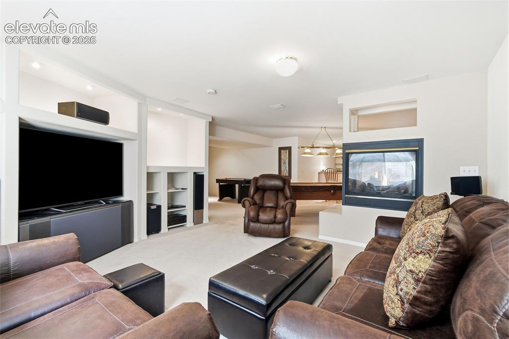 Image 34 of 50: Basement with 2 sided gas fireplace