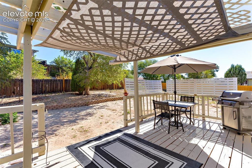 Image 20 of 24: Wooden deck featuring a pergola and grilling area