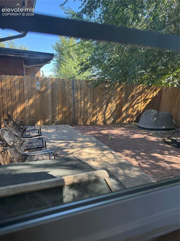 Image 16 of 17: Expansive backyard retreat featuring a wood-finish fence, mature shade tree