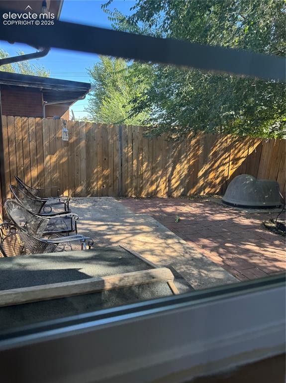 Image 17 of 17: Private backyard retreat featuring mature tree canopy, brick paver hardscap
