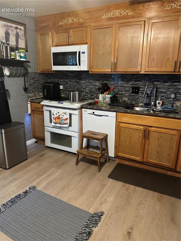 Image 7 of 17: Wood-finish flooring, wood cabinetry, dark speckled countertops, mosaic til