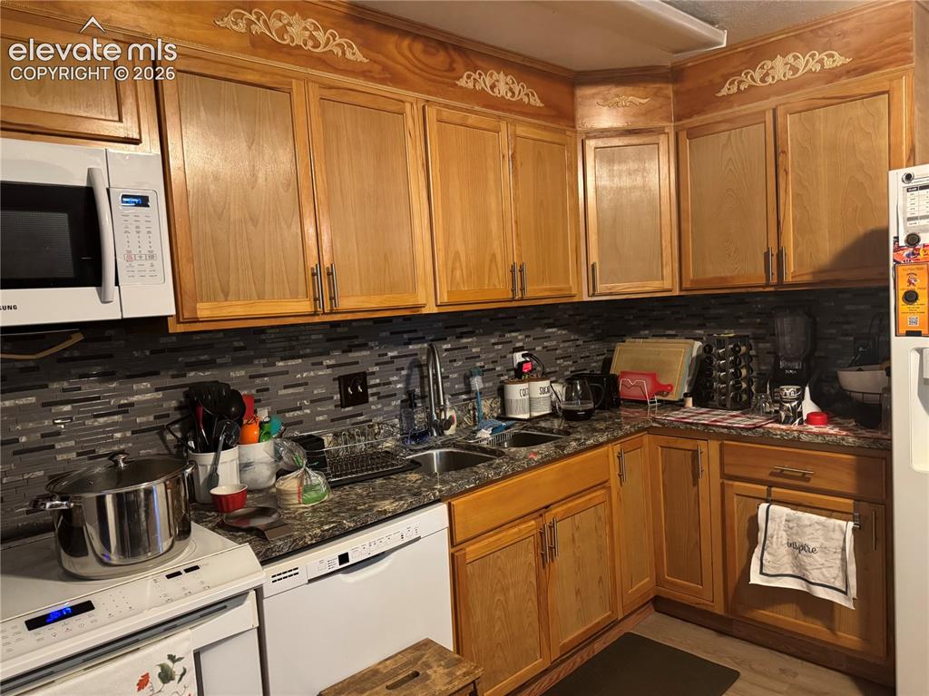 Image 9 of 17: Warm wood cabinetry with brushed metal hardware frames this kitchen, featur