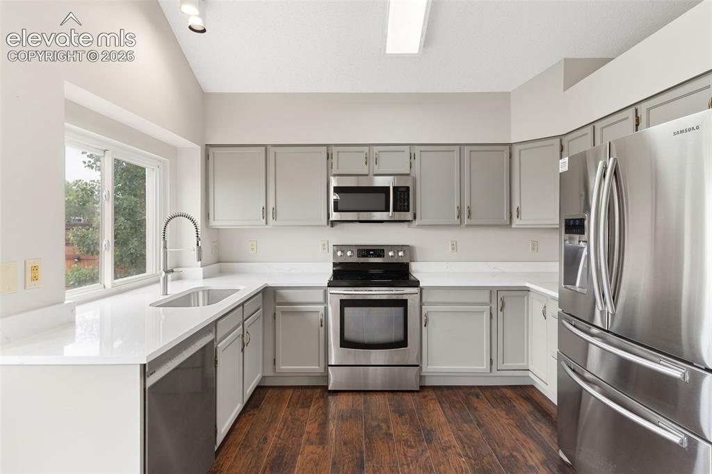 Image 13 of 38: Kitchen featuring wood-finish flooring, stainless steel appliances, light g