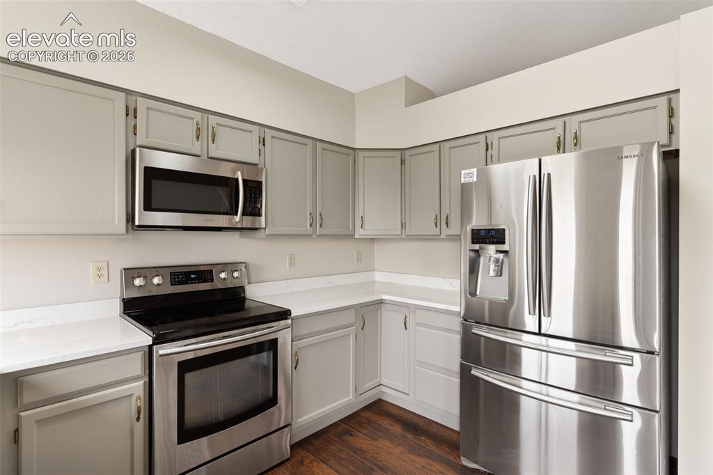Image 14 of 38: Kitchen featuring stainless steel appliances, light gray cabinetry, white c