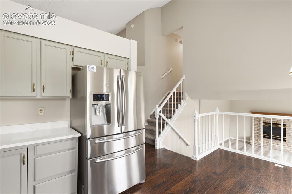 Image 15 of 38: Stainless steel French door refrigerator set within a kitchen featuring lig
