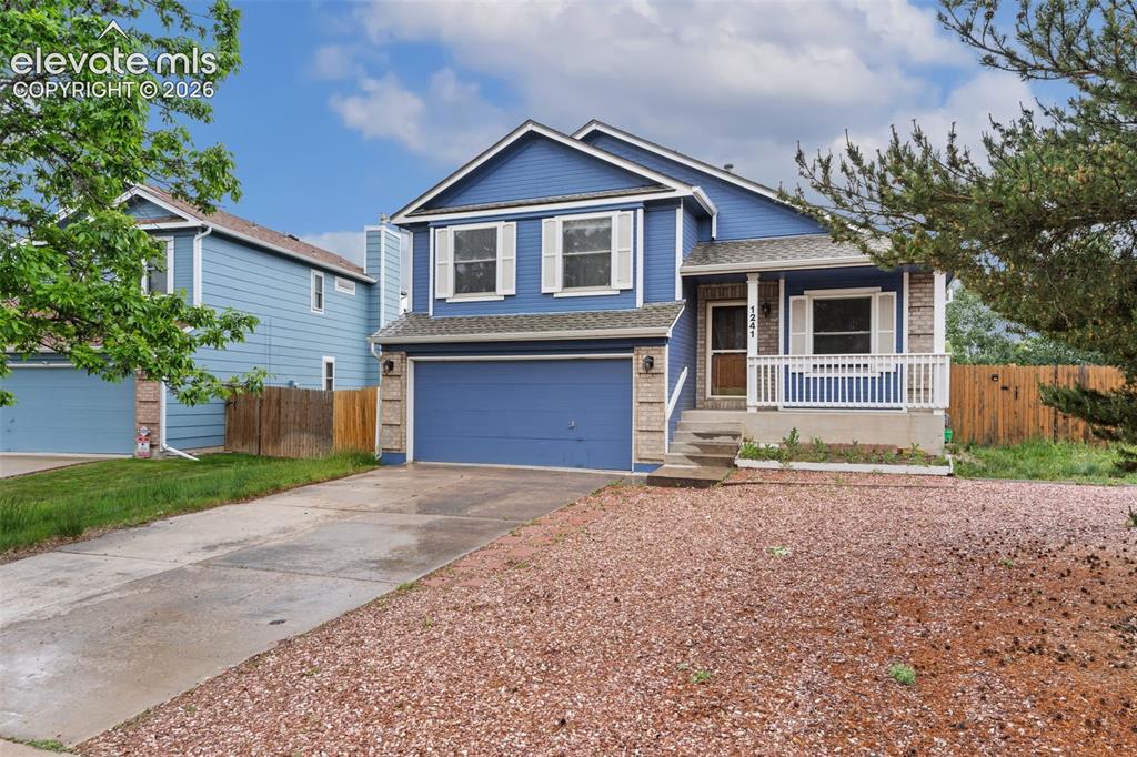 Image 2 of 38: Two-story residence featuring blue siding, white trim, and a covered front 