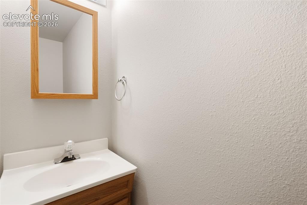 Image 21 of 38: Bathroom vanity with a white countertop and integrated sink, a single-handl
