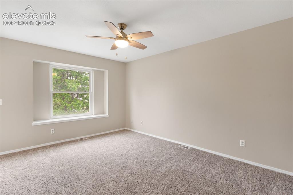 Image 22 of 38: Spacious room featuring neutral carpeting and wall tones