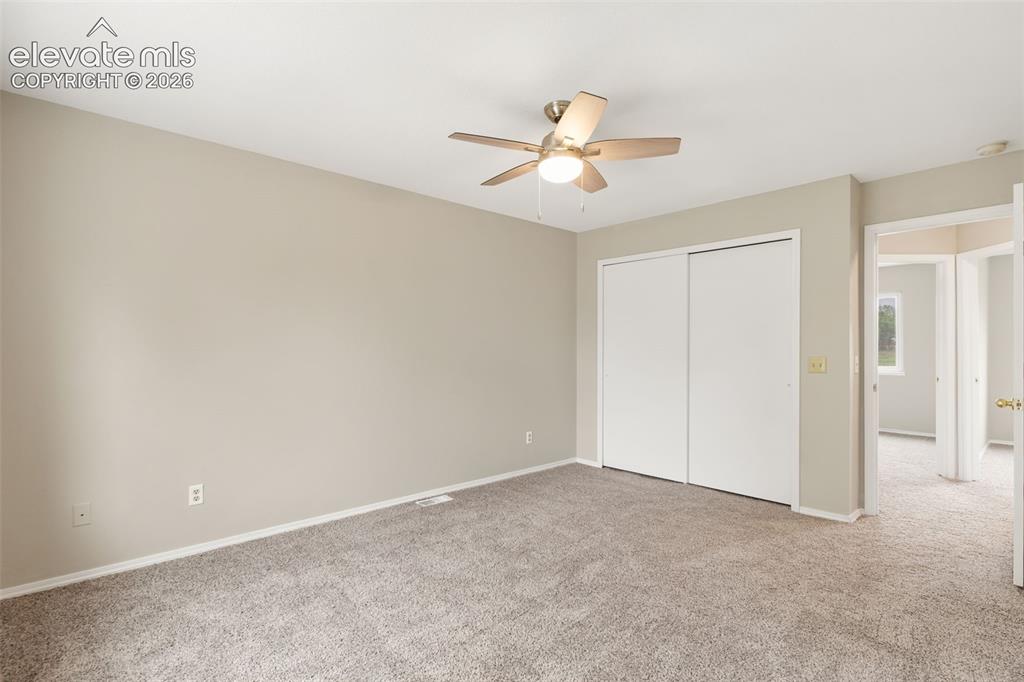 Image 23 of 38: Carpeted interior room featuring light-toned walls, white trim, and a ceili