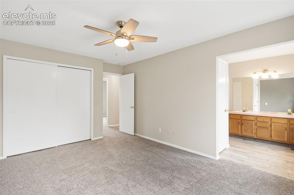 Image 24 of 38: Carpeted room featuring a ceiling fan with integrated lighting, sliding clo