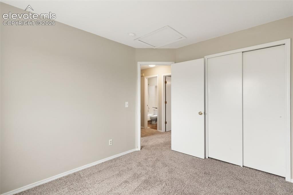 Image 27 of 38: Neutral-toned walls complement the textured gray carpeting