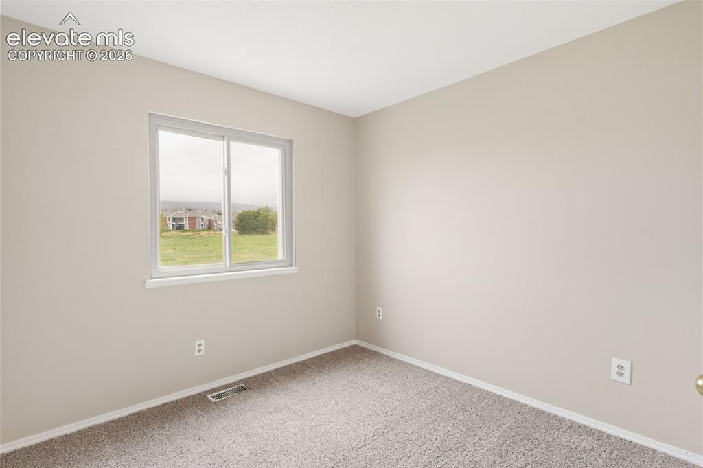 Image 28 of 38: Neutral-toned walls and trim with a carpeted floor