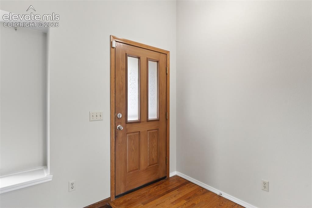 Image 3 of 38: Entryway featuring a wood-finish door with three frosted glass panels and p