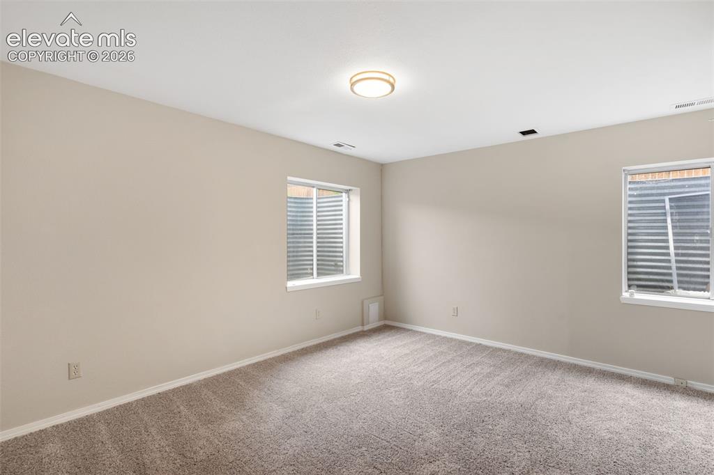 Image 31 of 38: Spacious room featuring neutral wall tones and a plush carpeted floor
