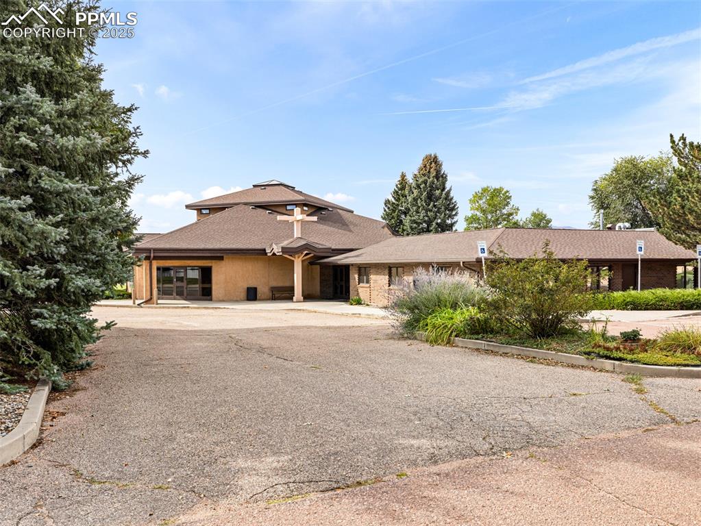 Caption: View of front of house with a shingled roof and driveway
