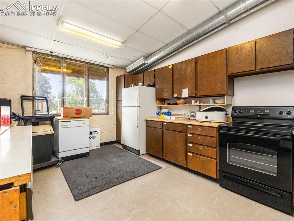 Image 35 of 49: Kitchen featuring light floors, white appliances, light countertops, a pane
