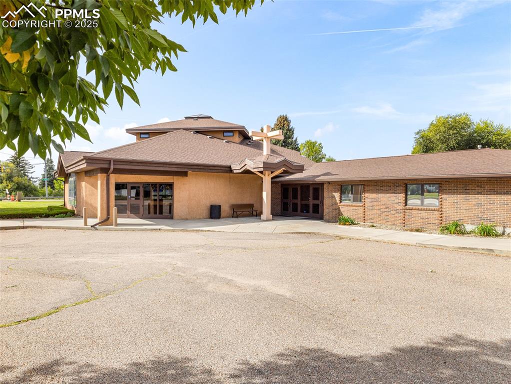 Image 4 of 49: View of front facade featuring a shingled roof and stucco siding