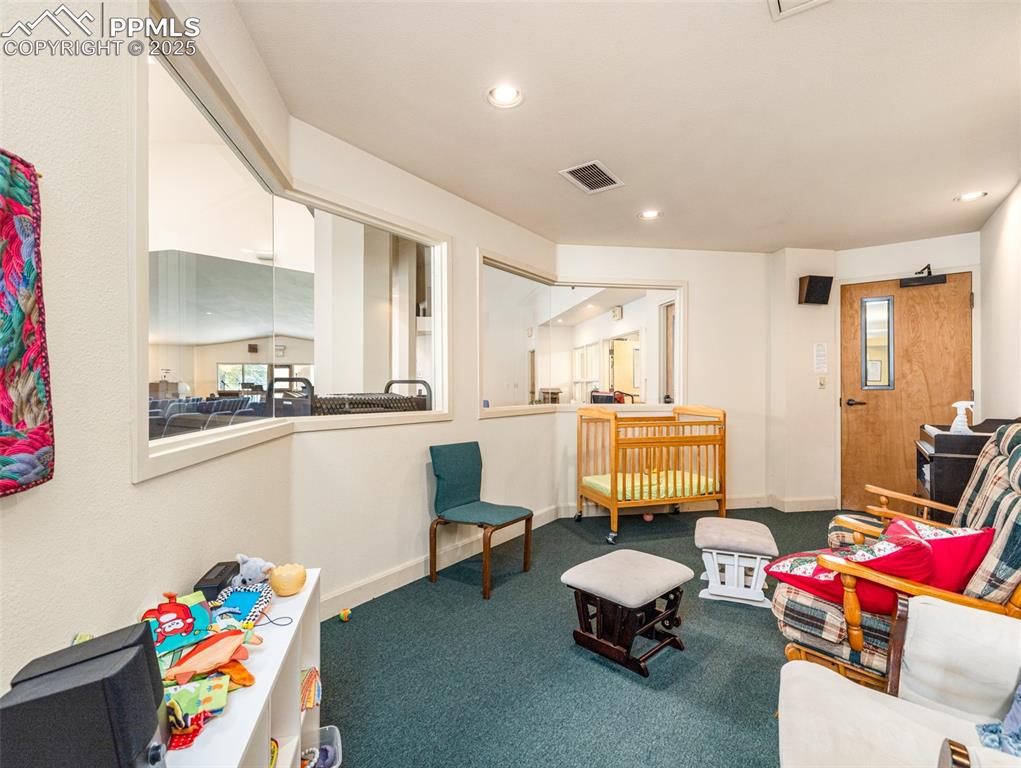 Image 47 of 49: Carpeted living area with recessed lighting