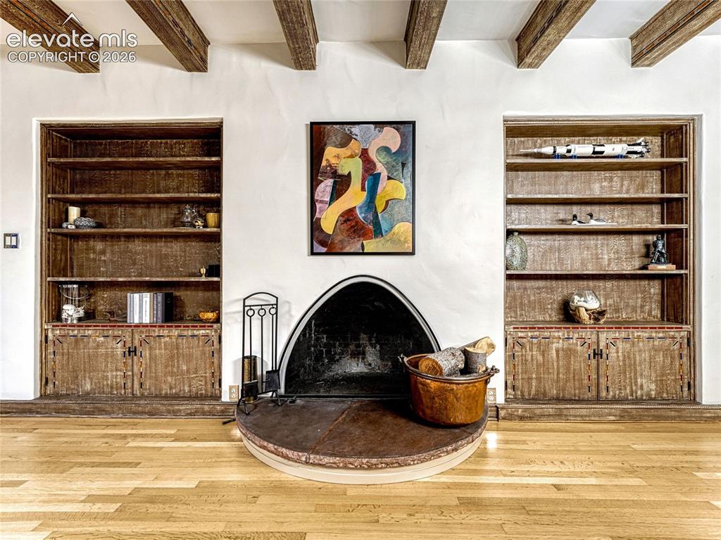 Image 10 of 50: Grand living/dining space has built-in bookcases and a wood-burning firepla
