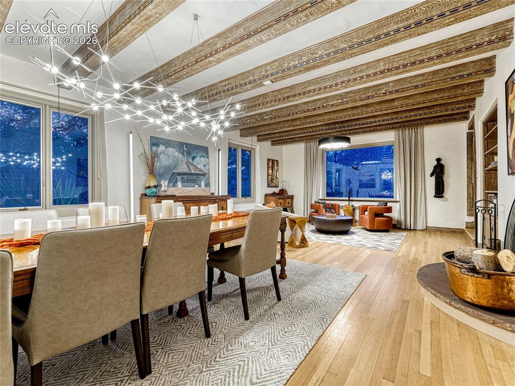 Image 11 of 50: Grand living/dining space anchored by a wood-burning fireplace