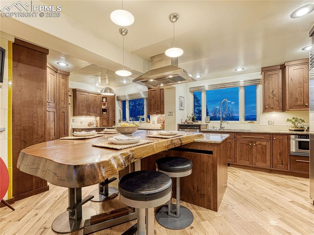 Image 19 of 50: Grand living/dining space has built-in bookcases and a wood-burning firepla