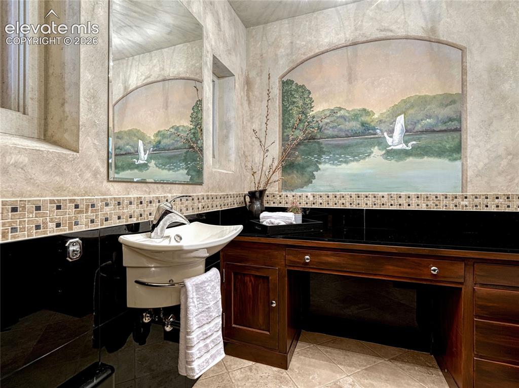 Image 20 of 50: The Elvis Room | Main Level guest bath with original mural artwork.
