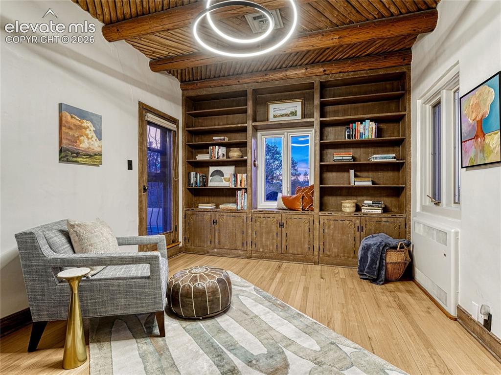 Image 22 of 50: Primary Suite sitting room has built-in bookcases with hand-carved, hand-pa