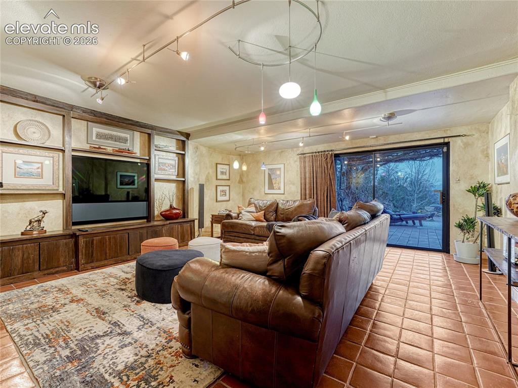 Image 38 of 50: Lower level family room with built-ins, cantina/wet bar and sliding glass d