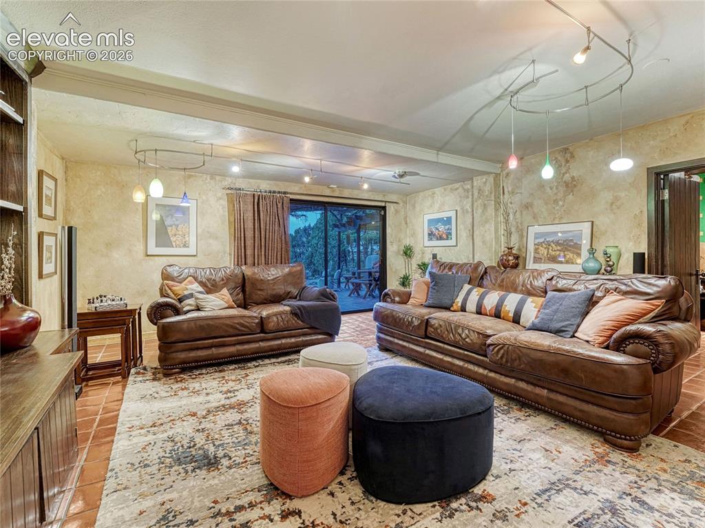 Image 39 of 50: Lower Level Family Room with original terra cotta tile floor.