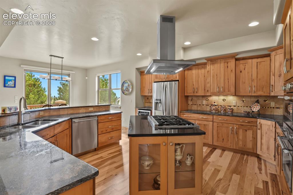 Image 10 of 48: Gourmet kitchen with wood-finish flooring, granite countertops, natural woo