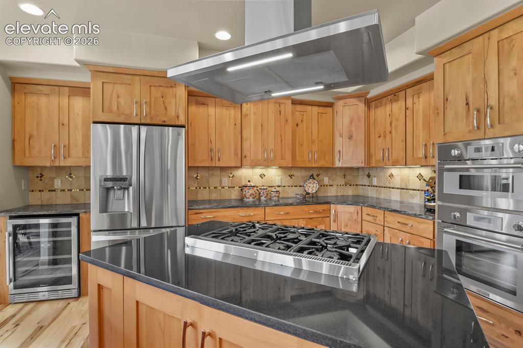 Image 13 of 48: Gourmet kitchen featuring a center island with a gas cooktop and range, sta