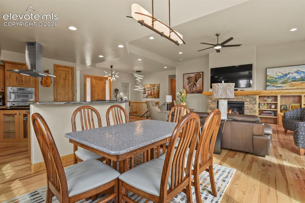 Image 15 of 48: Open-concept living area featuring a stone-faced fireplace, built-in shelvi