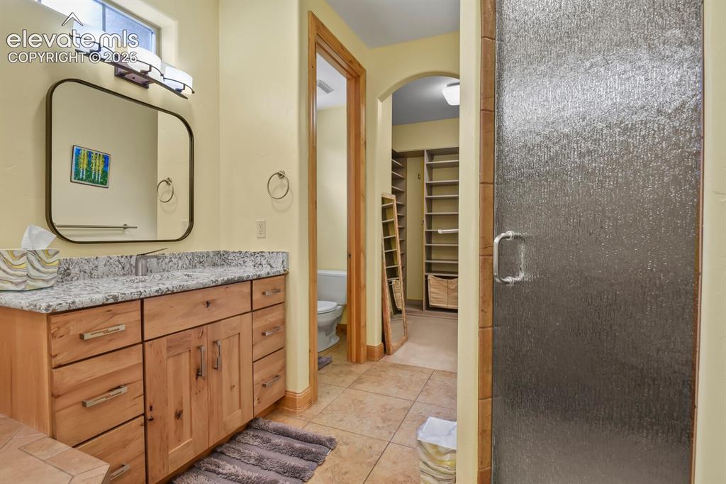 Image 21 of 48: Custom wood vanity with granite-style countertop, undermount sink, free sta