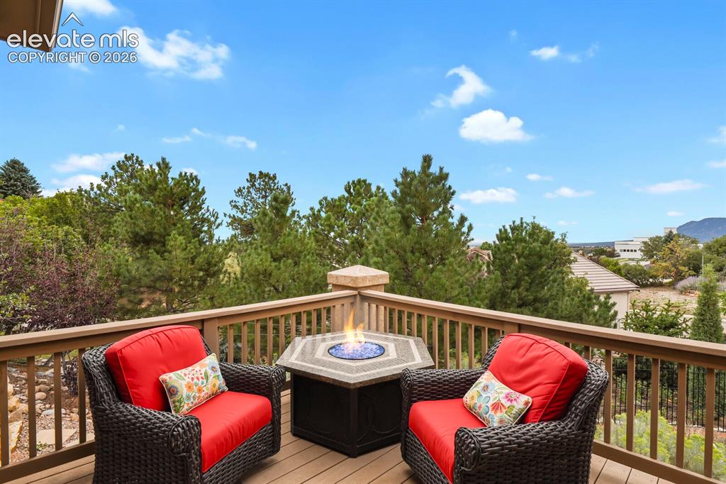Image 34 of 48: Expansive deck surrounded by mature trees and mountain/city views