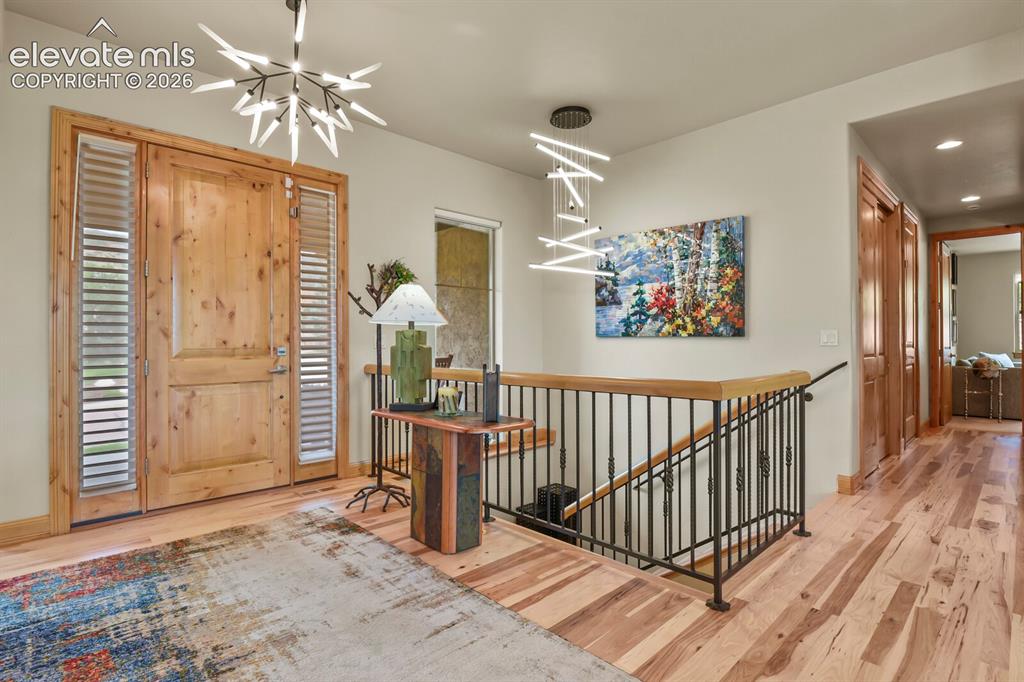 Image 4 of 48: Wood-finish flooring throughout, featuring a natural wood entry door with v