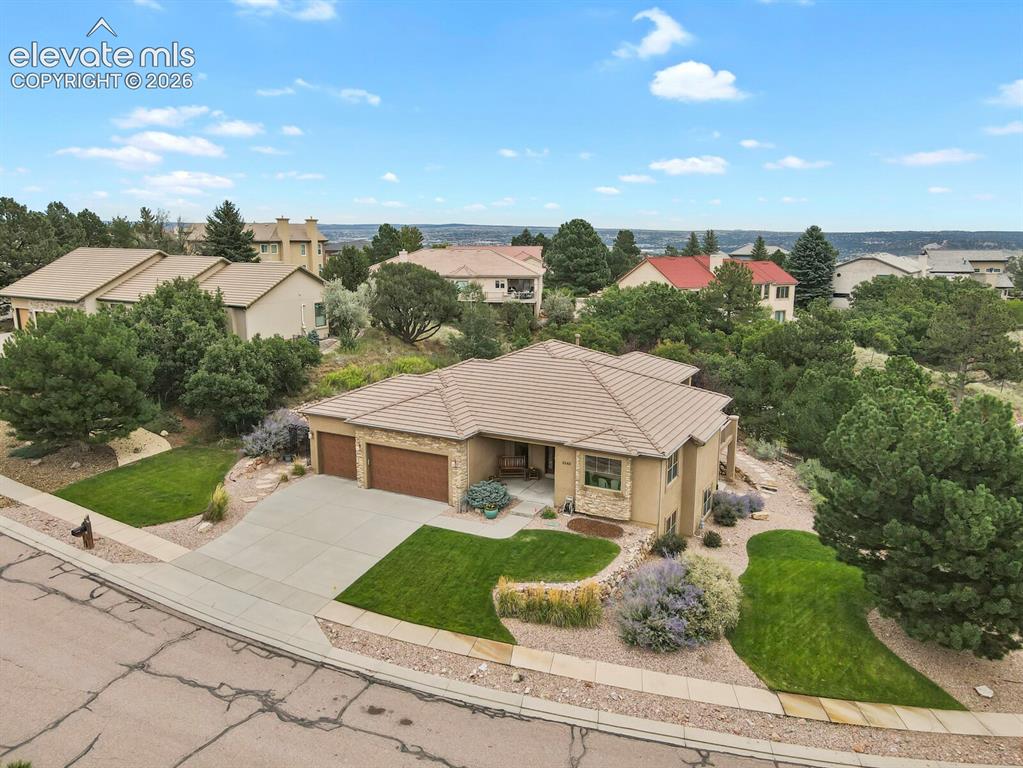 Image 41 of 48: Three-car garage, mature trees, manicured lawns, paved driveway, and establ