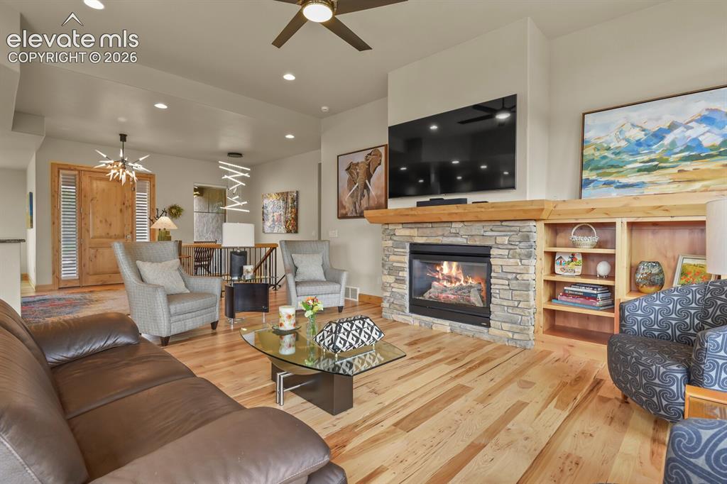 Image 6 of 48: Stone-faced fireplace with a natural wood mantel and built-in shelving, woo