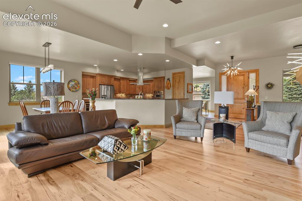 Image 7 of 48: Open-concept living area with wood-finish flooring, recessed lighting, and 