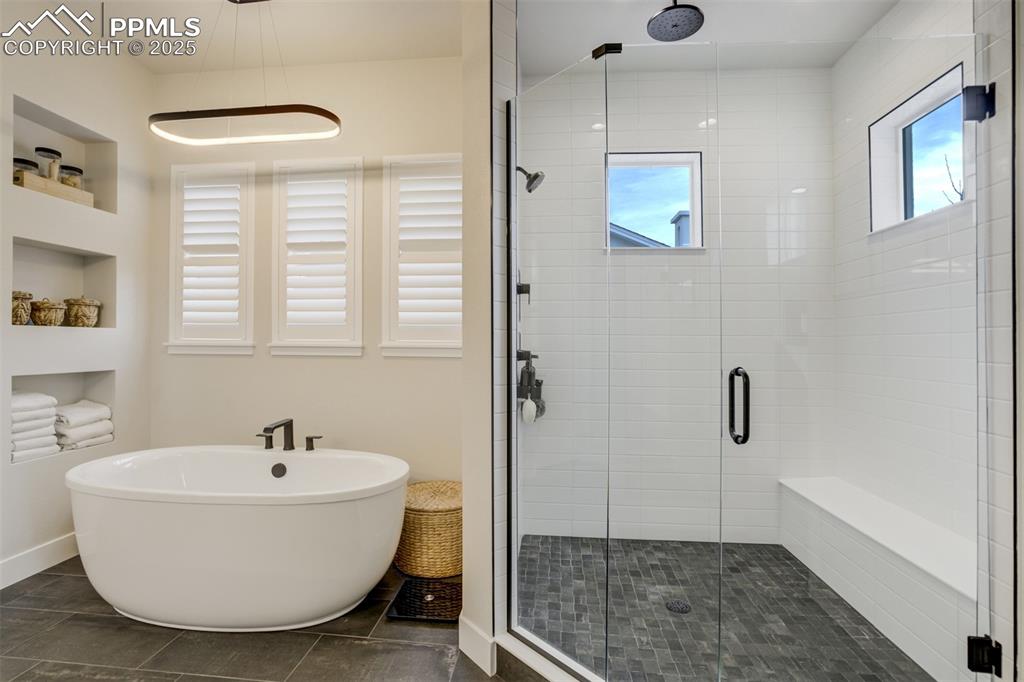 Image 20 of 47: Master bath featuring large shower w/seat, freestanding soaking tub, double