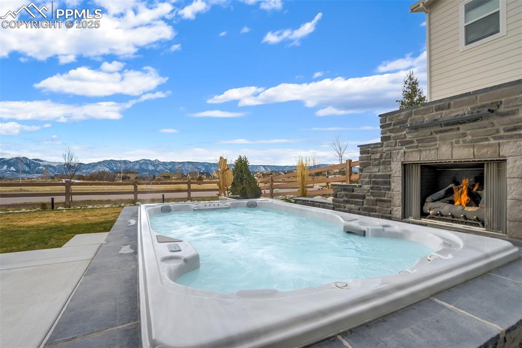 Image 40 of 47: SwimSpa nestled up to 1 of 3 outdoor fireplaces