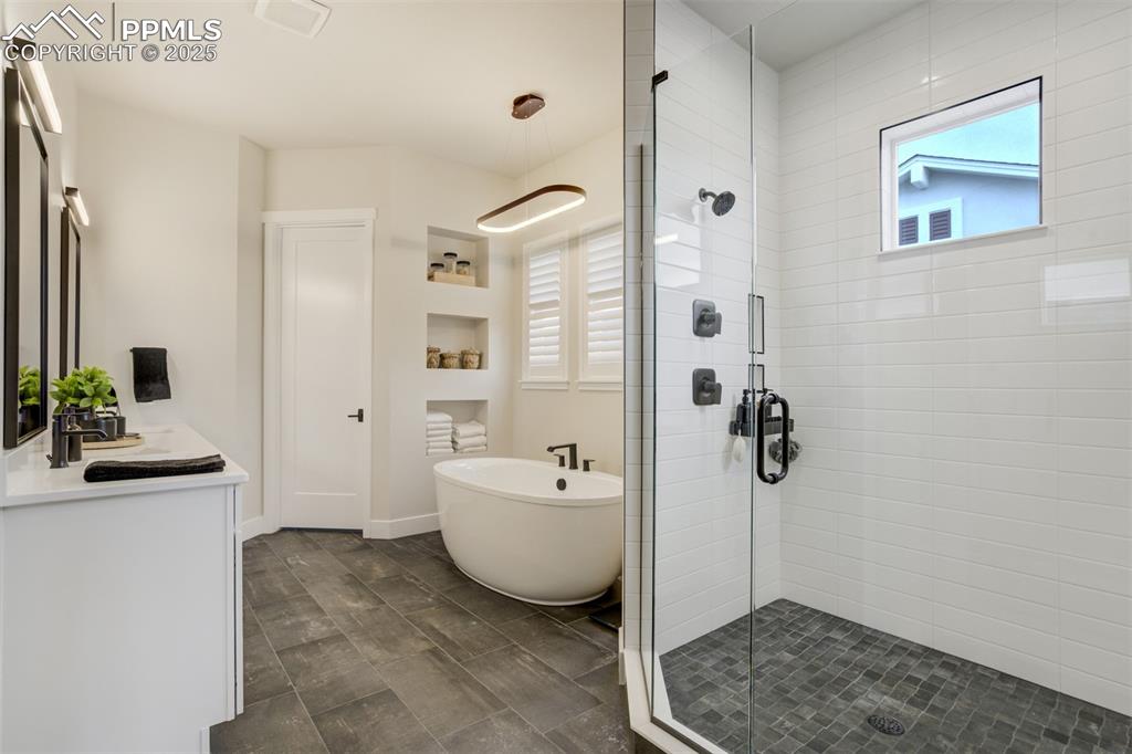 Image 7 of 47: Master bath featuring large shower w/seat, freestanding soaking tub, double