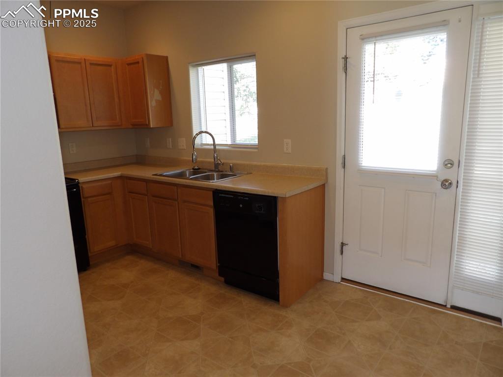Image 10 of 20: Kitchen featuring light countertops and black appliances
