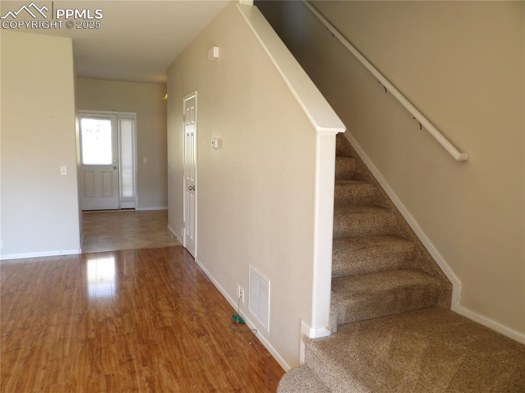 Image 5 of 20: Entryway featuring stairs and wood finished floors