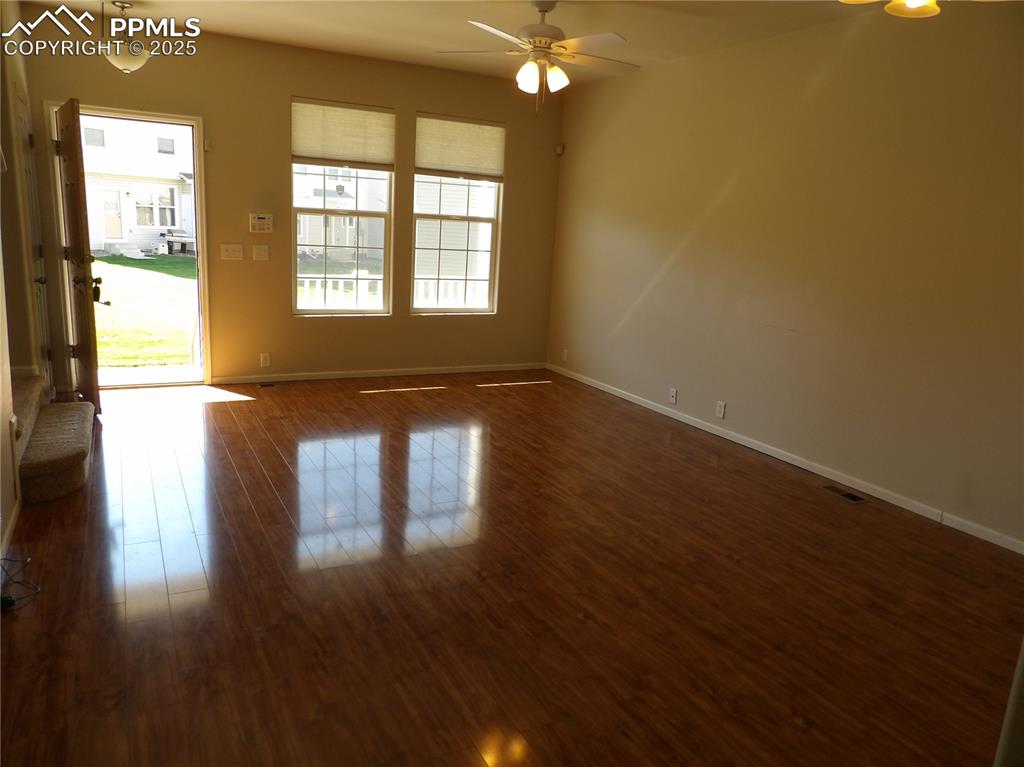 Image 6 of 20: Empty room with dark wood-style flooring and ceiling fan