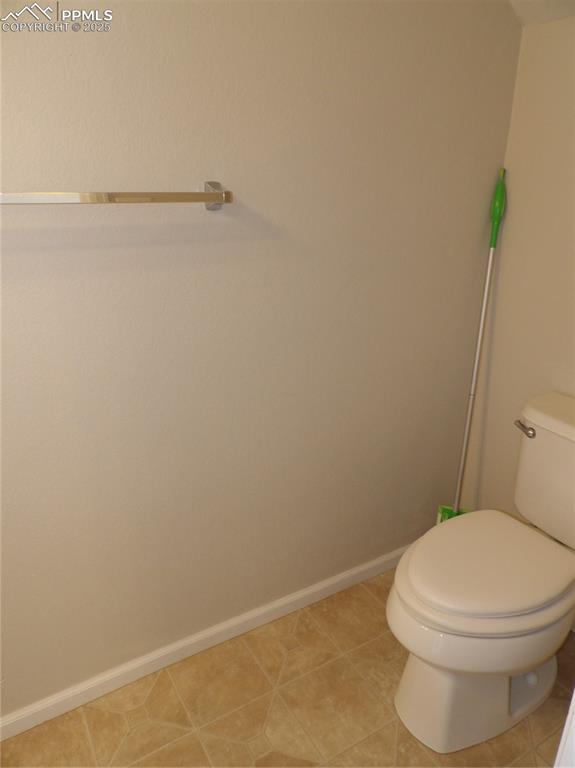 Image 8 of 20: Bathroom with toilet and light tile patterned floors