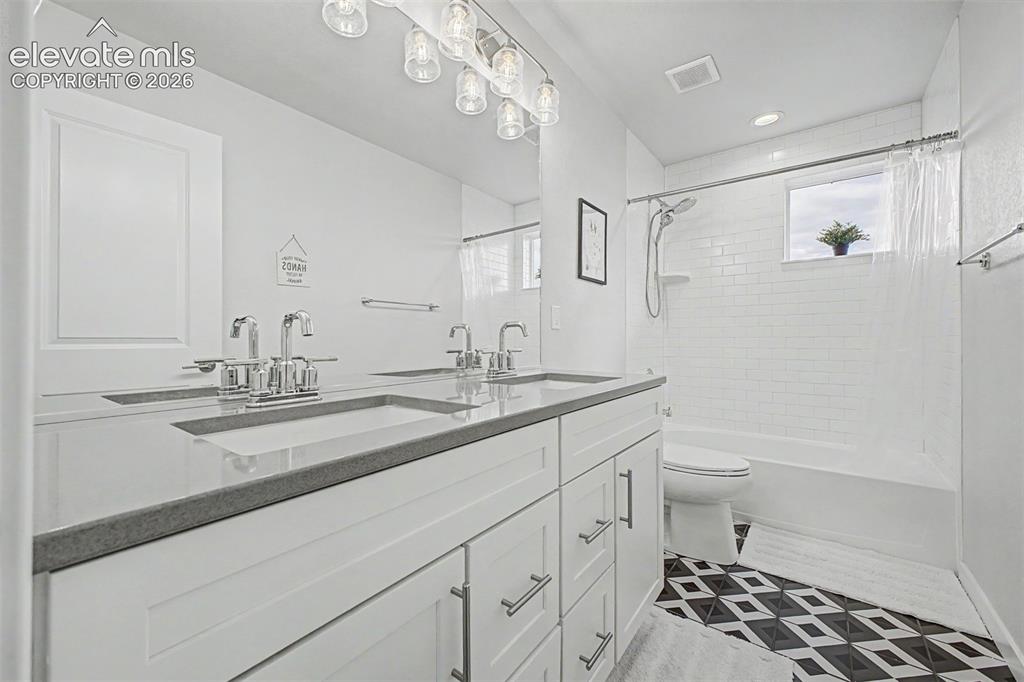 Image 31 of 50: Bathroom featuring a dual vanity with undermount sinks and chrome fixtures,