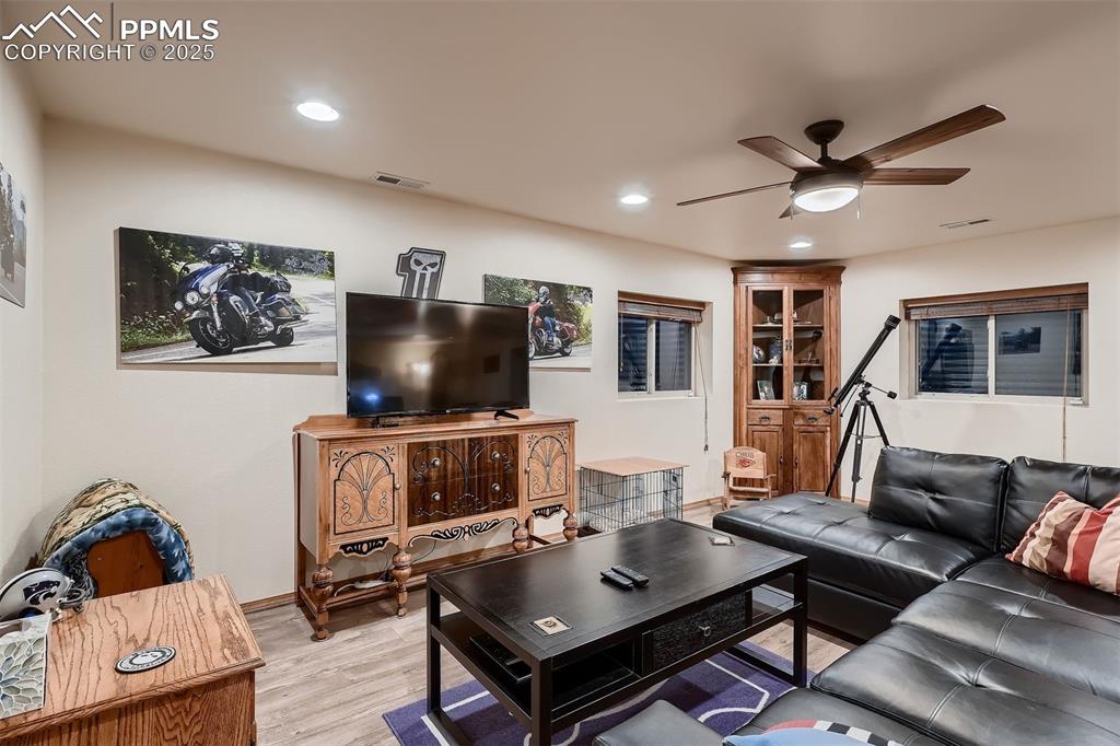 Image 19 of 28: Downstairs family room with vinyl flooring.