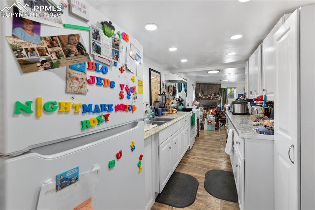 Image 10 of 37: The kitchen has white appliances, light countertops, and white cabinetry!