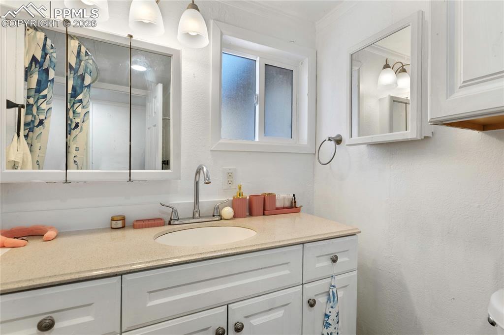 Image 21 of 37: The bathroom featuring vanity and ornamental molding!