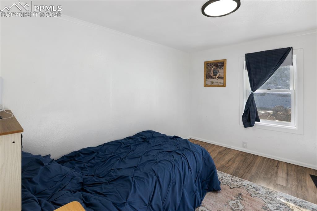 Image 23 of 37: The bedroom featuring wood finished floors and baseboards!